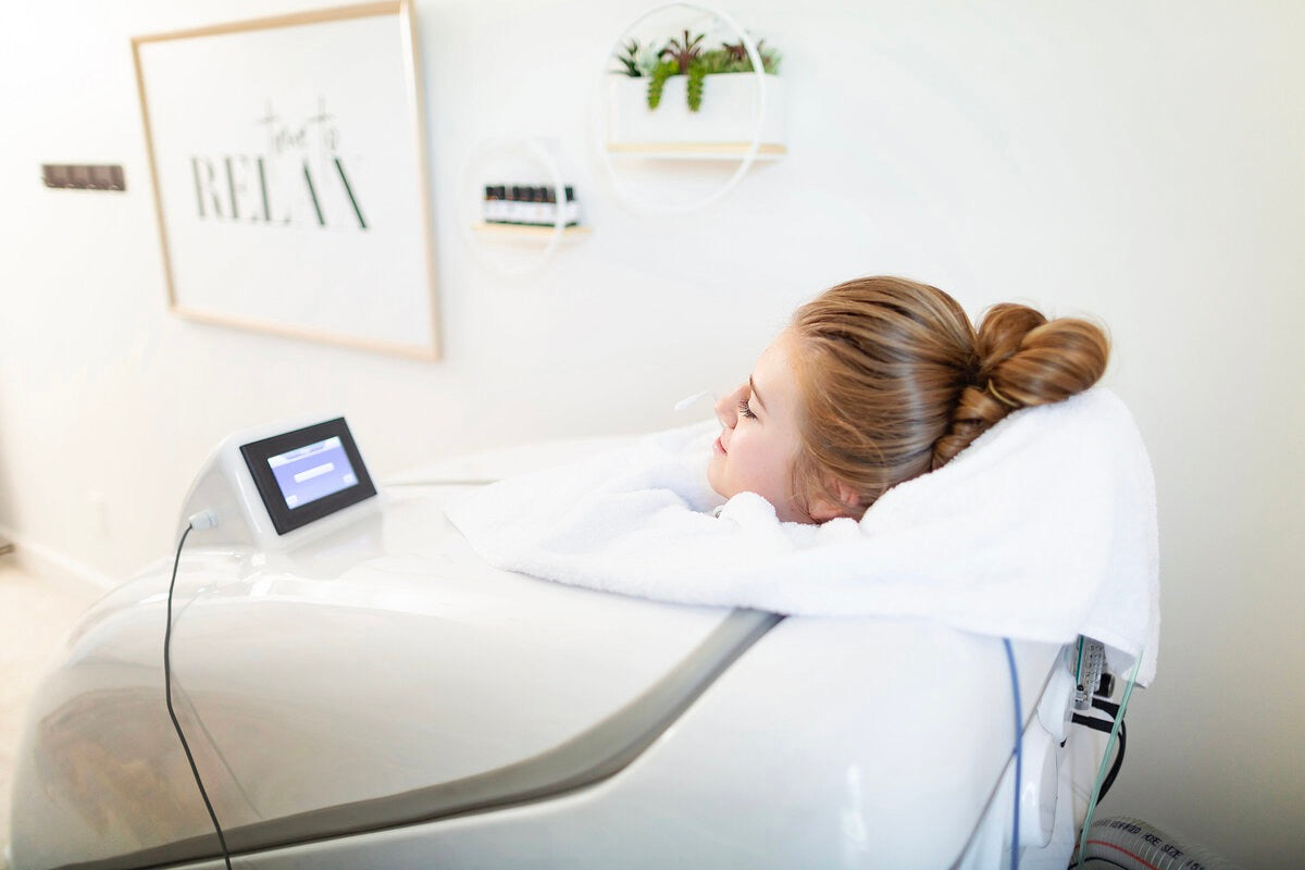 A client relaxes in an Oceanbeach oxygen HOCATT sauna, receiving PEMF therapy for wellness and detoxification.