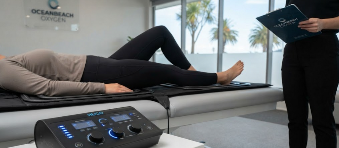 Generic view of a client receiving high-intensity HUGO PEMF therapy on a mat system in the Oceanbeach Oxygen clinic, Mount Maunganui, New Zealand, with the control unit visible.